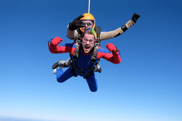 Skydiving. Tandem jump. Two men are having fun in the sky.