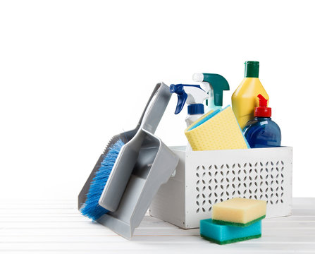 White wooden Basket with cleaning items on blurry spring background