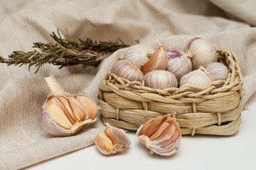 garlic solo in a wicker basket on a linen background.next to it is a canvas bag. eco condiments