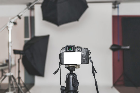 Mock up of a professional camera, in a photo studio, against the background of softbox light sources.