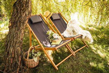 Two wooden deck chairs - summer outdoor leisure in the garden