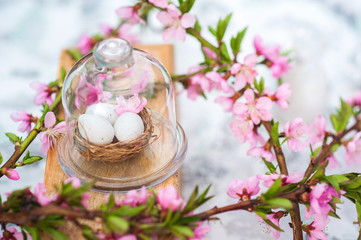 Quail eggs in a diy nest. Easter card in trendy color. Happy Easter concept with eggs and flowering branch. Spring, easter, eggs close-up and copy space.