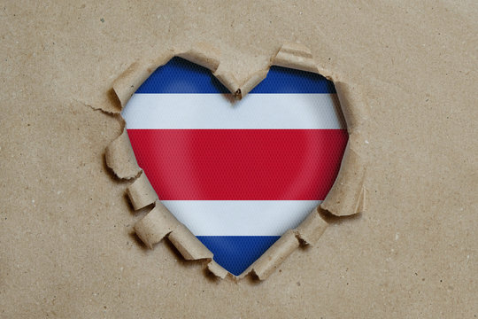 Heart shaped hole torn through paper, showing Costa Rica flag