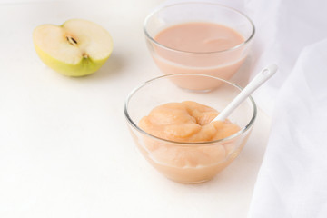 two glass bowls with homemade baby puree on a white background. copy space