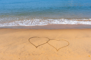 14 February. Valentine's Day. Two hearts drawn in the sand. Day of lovers. Congratulations. Sandy tropical beach with painted hearts. 
