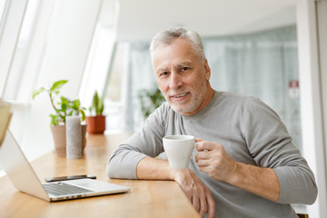 Senior businessman sit in cafe drinking coffee.