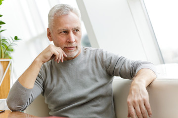 Senior grey-haired bearded businessman sit in cafe.