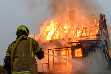 Norwegian firefighter trying to put out flames house on fire