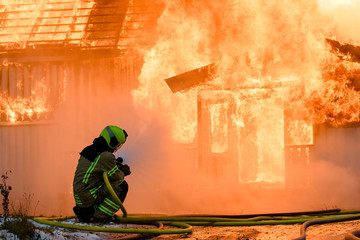 Norwegian firefighter trying to put out flames house on fire