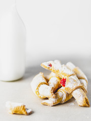 bagels in icing sugar on a white background, a bottle with milk nearby, high key