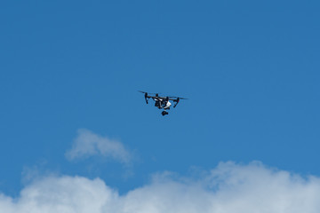Naklejka na ściany i meble Drone flying against blue sky with white clouds below