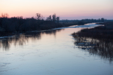 the nature of the spring flood the river ice trees water reflection
