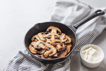 Delicious fried mushrooms with flat bread and herbs on the wooden table