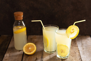 Preparation of the lemonade drink. Lemonade in the jug and lemons with mint on the table outdoor