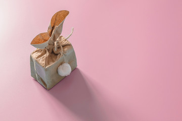 Top view shot decoration Easter background concept. Flat lay minimalism paper bag same bunny or rabbit for gift or present on pink paper.