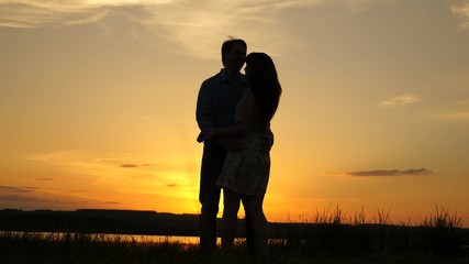 Young couple dancing at sunset on beach. Happy guy and girl waltz in evening in summer park. Loving...
