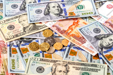 Various coins lying over different currency banknotes dollars and rubles