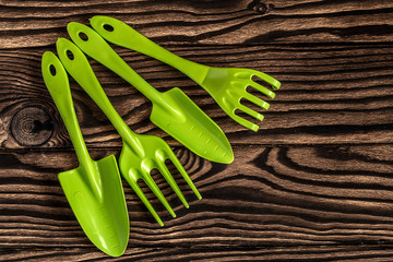 Gardening tools concept. Spade, rake and fork on wooden background with space for text flat lay top...