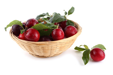 Red plums on wicked plate