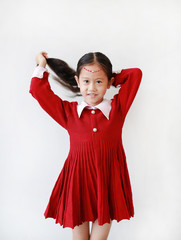 Portrait of pretty little child girl in princess dress with smiling and expression tying up her hair isolated on white background.