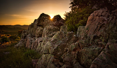 Rocks in the mountain landscape and sun rays during sunset in Almodovar del Campo, Spain