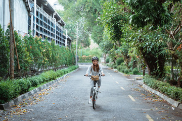 young women riding folding bikes on the road and wearing helmets to safety and enjoy the trips