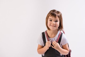 portrait girl of Asian appearance 7 years old schoolgirl in school uniform with backpack on an...