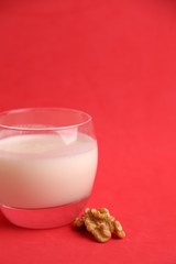 glass of walnut milk in color background