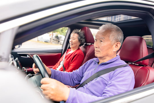 Happy asian senior couple  driving car