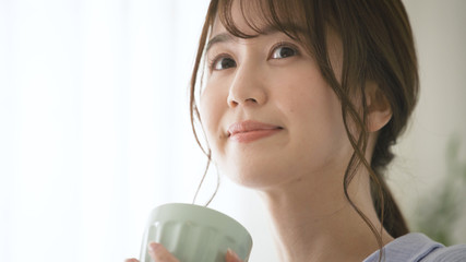 パジャマ姿でマグカップを持つ女性