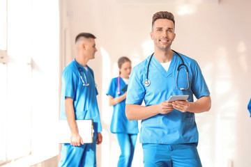 Male medical student with tablet computer in hall of clinic