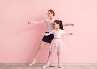 Little ballerina training with coach against color background