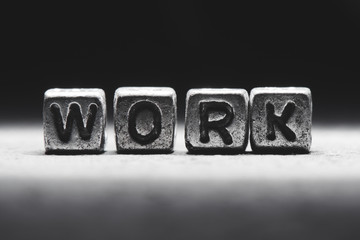 Naklejka premium Work concept. 3d inscription on metal cubes on a gray black background isolated