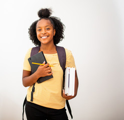african american teenage girl student holding  bag and books