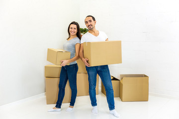 Packed and ready to move in new house. Excited young spouses with boxes in hands, on their way into new apartments.
