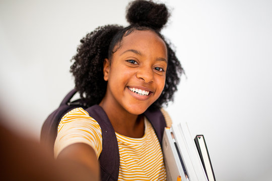 Close up african girl student taking selfie against isolated white background