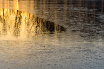 Half frozen lake at sunset