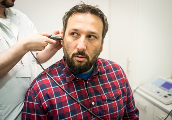 Obraz premium Doctor in hospital checking patient ear
