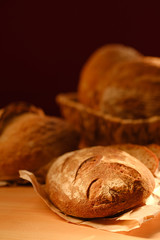 Assortment of baked bread on wooden table background. Bread background, top view of white, black and rye loaves. Healthy food. 