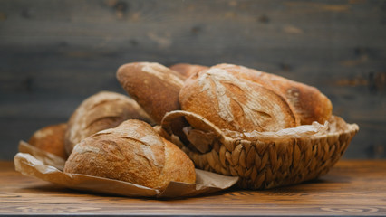 Assortment of baked bread on wooden table background. Bread background, top view of white, black and rye loaves. Healthy food. 