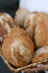 Assortment of baked bread on wooden table background. Bread background, top view of white, black and rye loaves. Healthy and nutritious food. The product contains carbohydrates.
