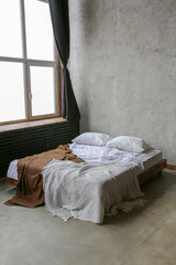 loft interior with a bed. minimalism. grey wall with window