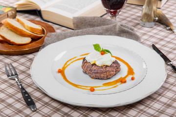 steak with poached egg in a brown cage