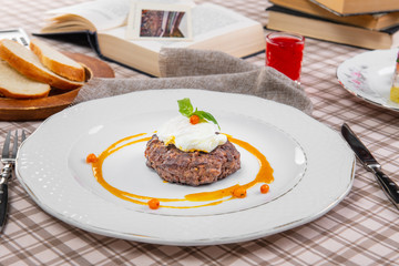 steak with poached egg in a brown cage