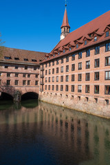Obraz premium Blick auf das Heilig-Geist-Spital am Fluss Pegnitz in Nürnberg/Deutschland