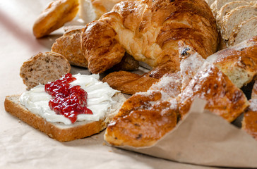 Variety of breads and a touch of strawberry jam.