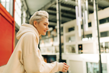 Blond young woman with short hair indoors