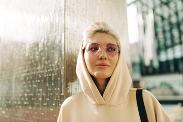 Blond young woman with pink sunglasses