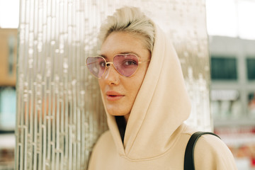 Blond young woman with pink sunglasses