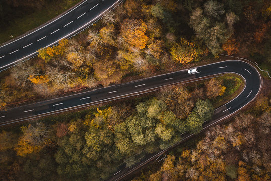 Aerial view of a road trip on a meandering road through forests during autumn in Cochem, Germany, Europe